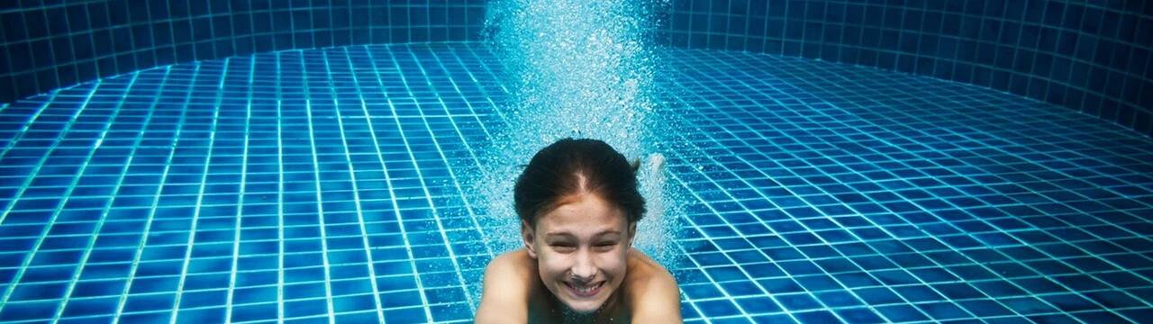 Girl in swimming pool underwater glass mosaic tiles waterproofing solutions tile adhesive and grouting